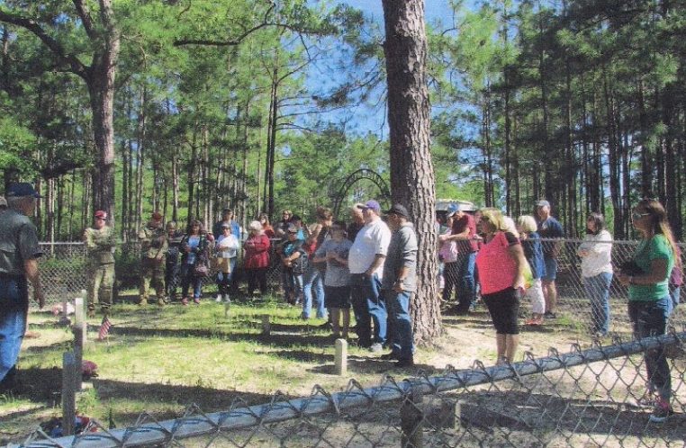 Peason Ridge Tour group being briefed at the Merritt Cemetery by Cultural Resources Specialist Scott Faris of Ft. Polk and Rickey Robertson, Peason Ridge Heritage family member. (Kim Wallace Photo)